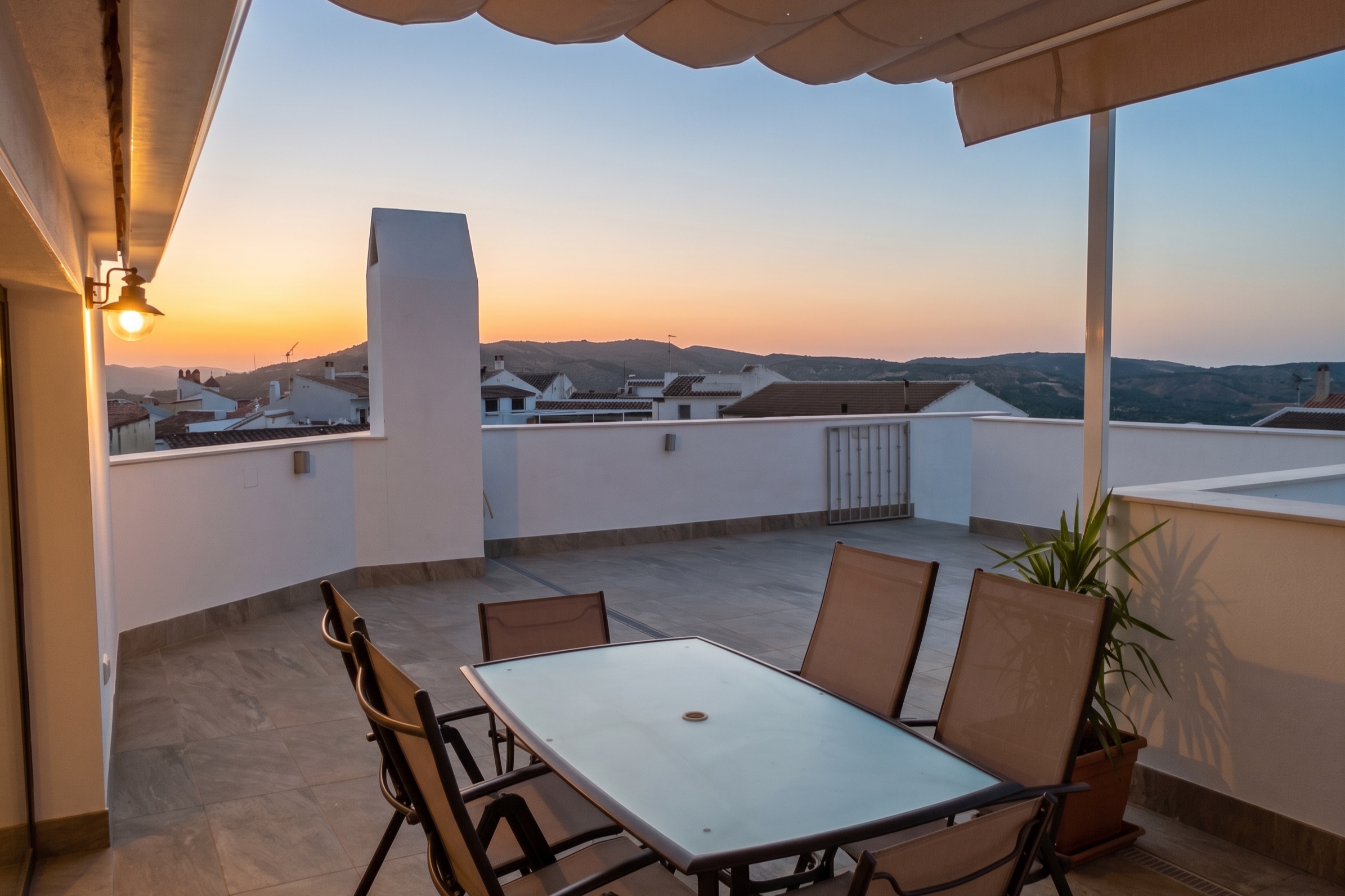 Terraza del Ático al atardecer, con la mesa y los tejados de Zuheros