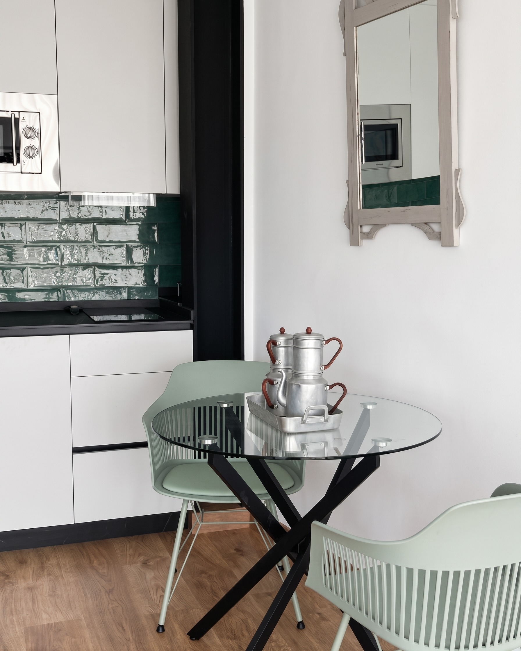 Cocina verde con mesa redonda de madera